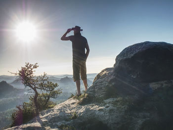 Trekker in cowboy hat enjoy view on the mountain with beautiful sunrise and sea of mist in morning