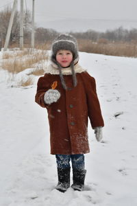 Full length of girl standing on snow covered land