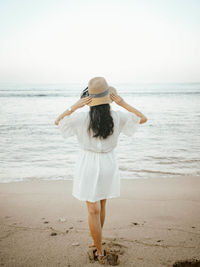 Rear view of woman with umbrella on beach