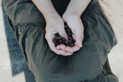 Midsection of woman holding dried fruit