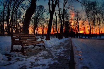 Empty bench on snow covered landscape