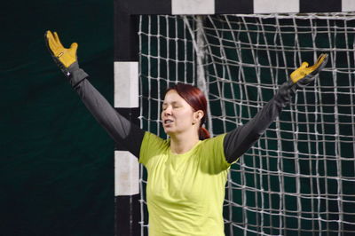 Female goalie with arms raised