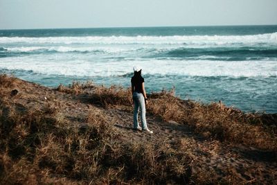 Rear view of man walking on beach