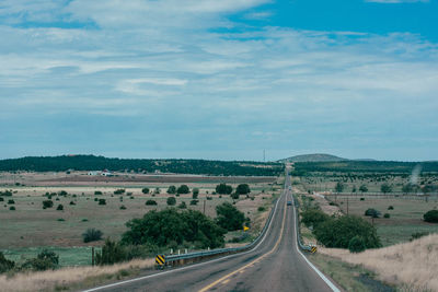 Road leading towards city against sky, arizona