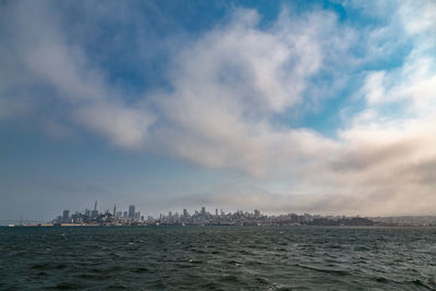 Scenic view of sea by buildings against sky