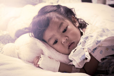 Close-up of cute girl lying down on bed