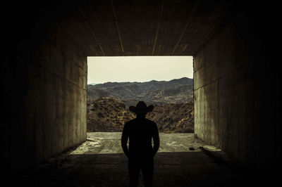 Rear view of man standing in tunnel