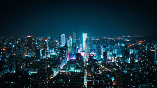 Illuminated cityscape against sky at night