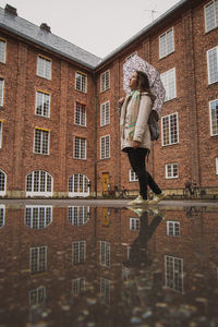 Woman standing against building