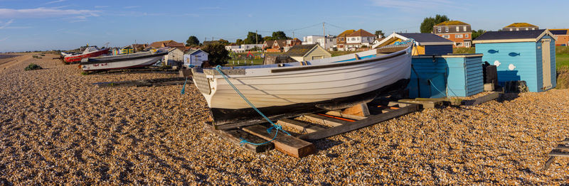 Boats moored on beach against sky