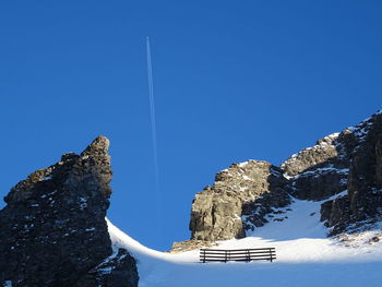 Low angle view of vapor trail against clear blue sky