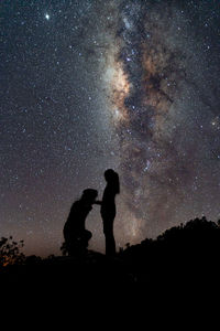 Silhouette people standing against sky at night