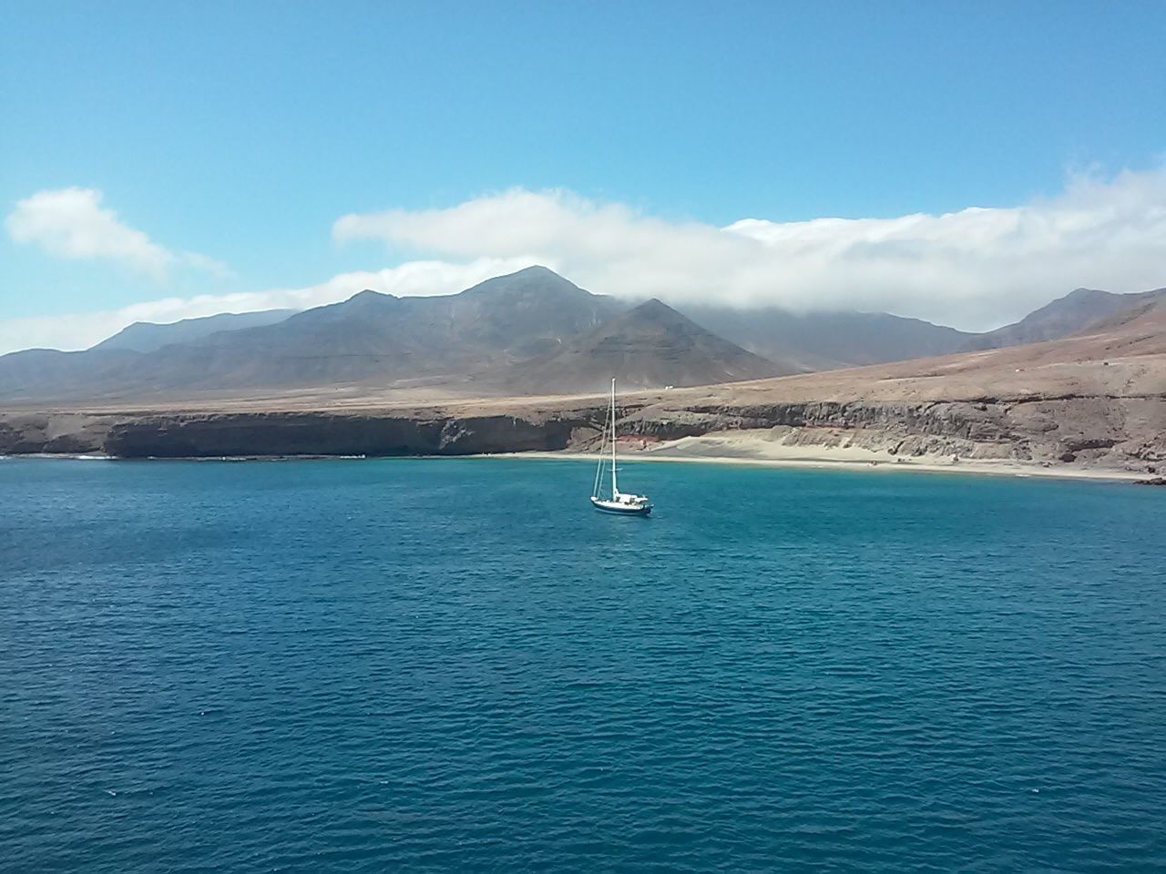 water, blue, sky, mountain, beauty in nature, sea, outdoors, day, mountain range, waterfront, cloud - sky, tranquility, scenics, nautical vessel, nature, no people