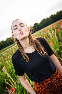 Young woman with arms raised on field