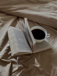 High angle view of coffee cup on bed