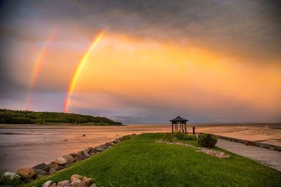 Scenic view of rainbow over sea against sky