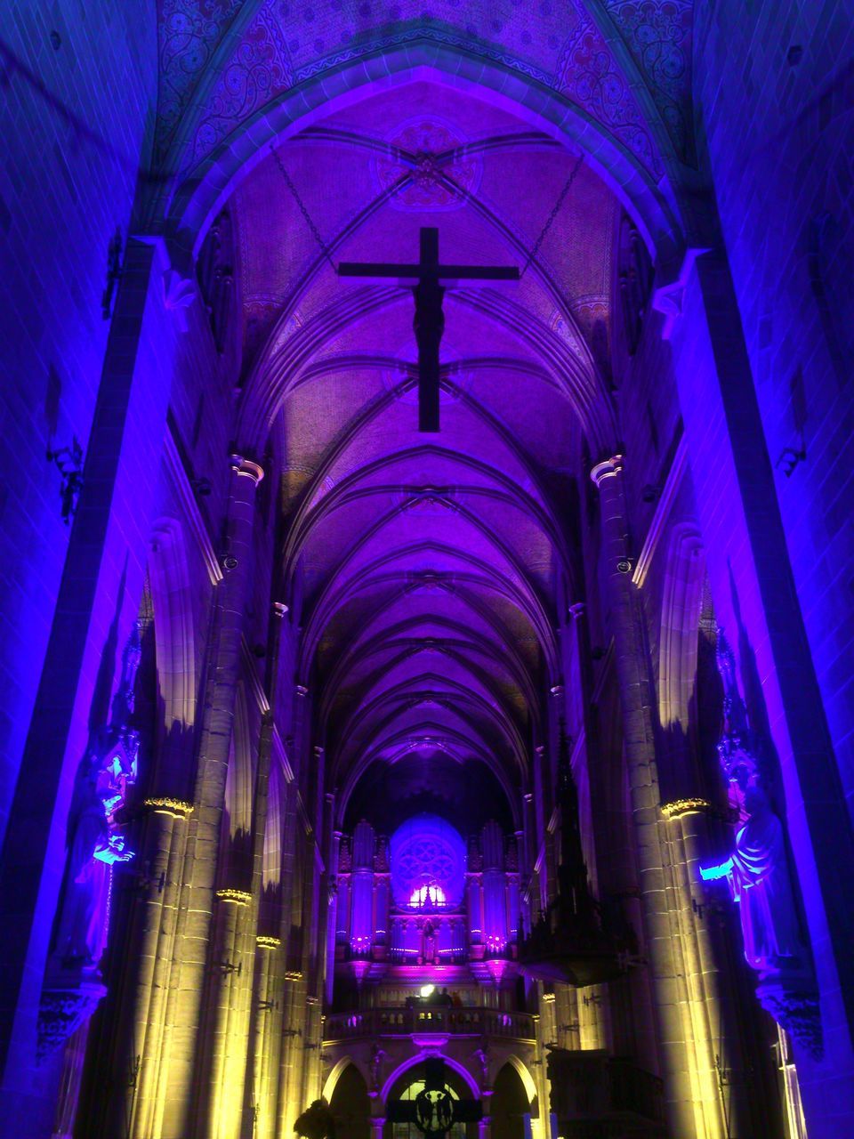 arch, low angle view, architecture, indoors, diminishing perspective, ceiling, illuminated, in a row, architectural feature, column, geometric shape, arched, majestic, architectural column, multi colored, tall, lit, no people, pink color