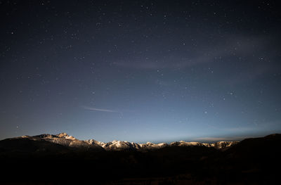 Silhouette landscape against star field at night