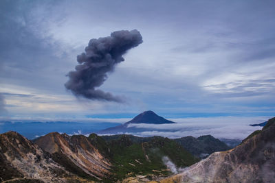 Smoke emitting from volcanic mountain against sky