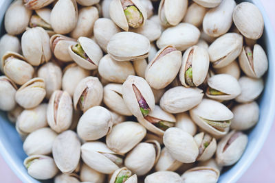 Pistachio in shell in bowl on pink background