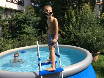 Brothers enjoying summer in wading pool at back yard
