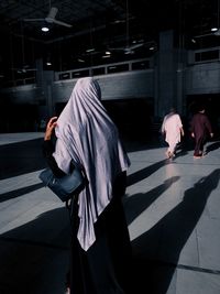 Rear view of people walking on footpath