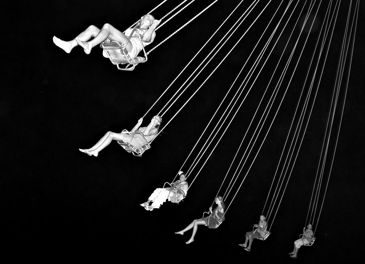 LOW ANGLE VIEW OF FISHES SWIMMING IN SEA AGAINST BLACK BACKGROUND