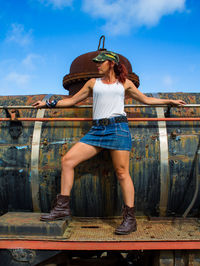 Full length of young woman standing against train