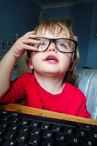 Portrait of boy wearing eyeglasses at home