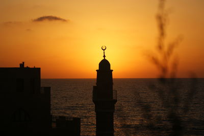 Silhouette mahmoudiya mosque minaret against sea during sunset
