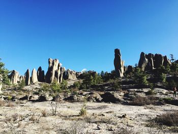 Rock formations in desert against clear blue sky