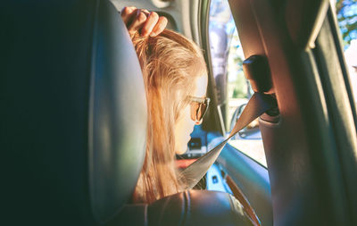 Rear view of young woman sitting in car