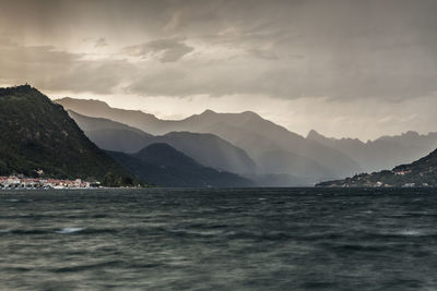 Scenic view of sea and mountains against sky