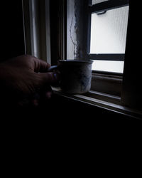 Hand holding coffee cup at home