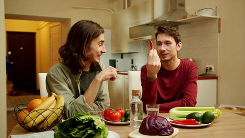 Gay couple sitting at dining table