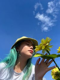 Portrait of young woman against blue sky