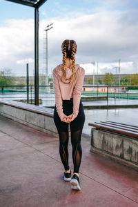 Young sportswoman stretching arms and back outdoors