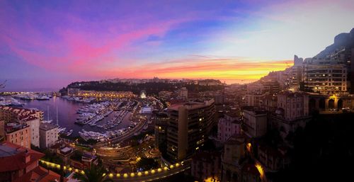 High angle view of city lit up at sunset