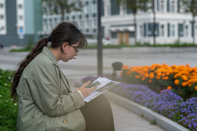 Young woman using mobile phone in city