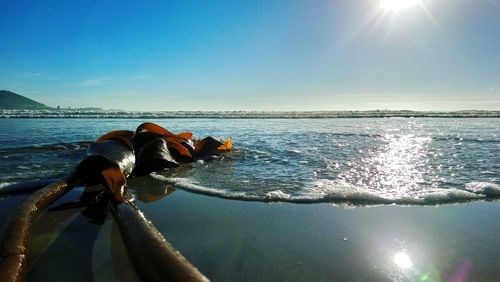 Man surfing in sea against sky on sunny day