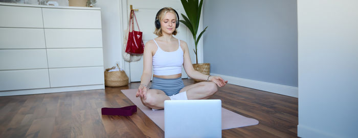 Portrait of young woman using digital tablet while sitting on table