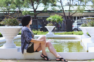 Portrait of woman sitting on slide at park