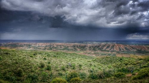 Scenic view of field against cloudy sky