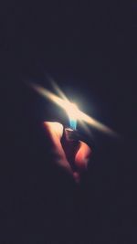 Cropped image of hand holding illuminated lamp