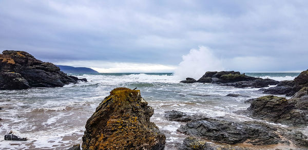 Panoramic view of rocks on beach against sky