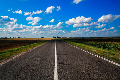 Surface level of country road against cloudy sky