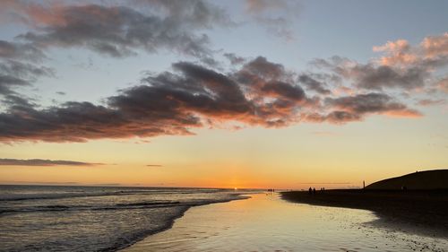 Scenic view of beach against sky during sunset