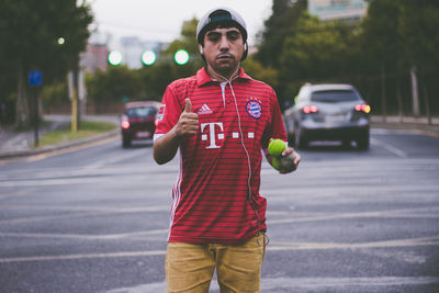 Portrait of young man standing on road