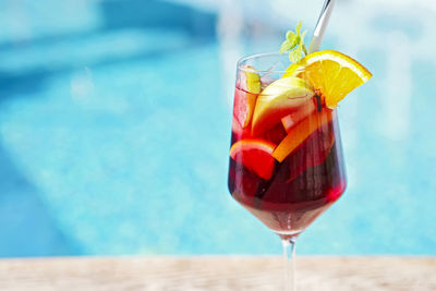 Close-up of drink on table against swimming pool