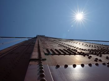 Low angle view of sun shining through blue sky